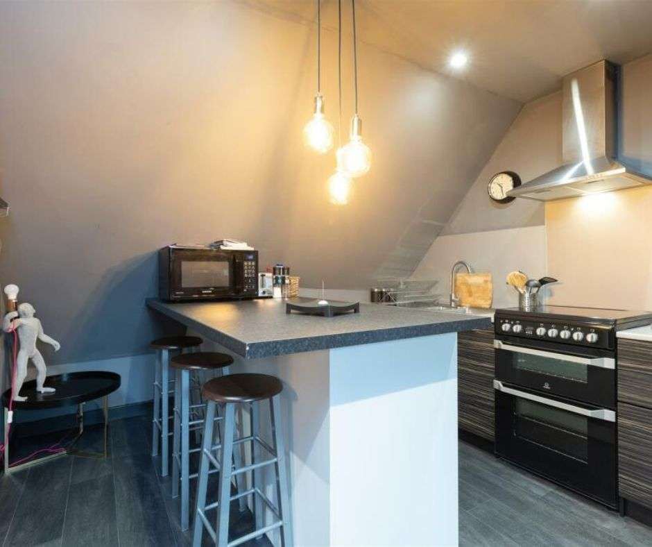 The converted attic kitchen in Dunkeld, under a sloping ceiling with pendant bulbs
