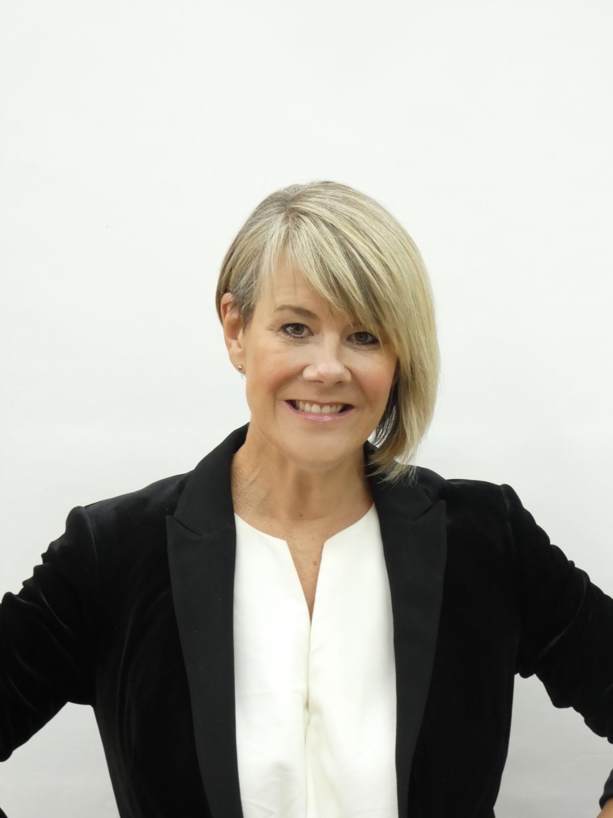 Elina James in a black velvet blazer, smiling